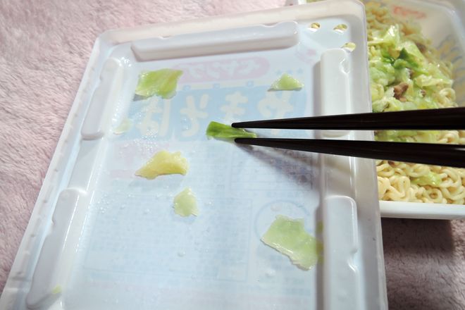フタの裏に付いたキャベツを箸で容器に戻す