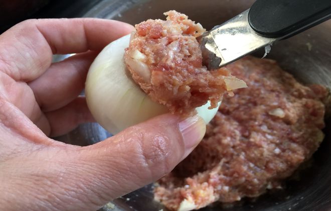 玉ねぎにひき肉を詰める作業