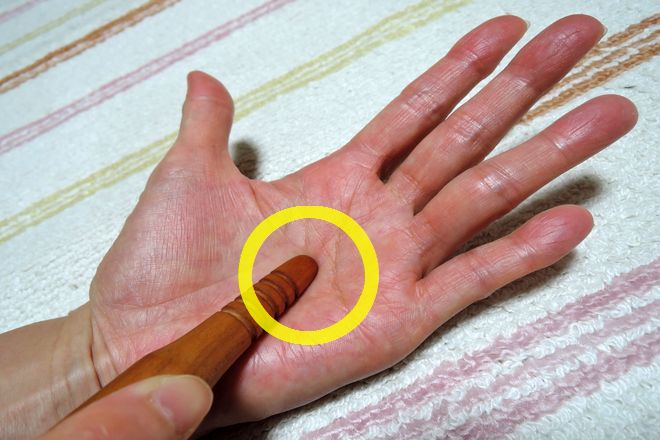 労宮をツボ押し棒で刺激します。