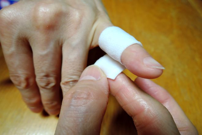 小指の第一関節と第二関節の間に小指湿布を巻いていきます。